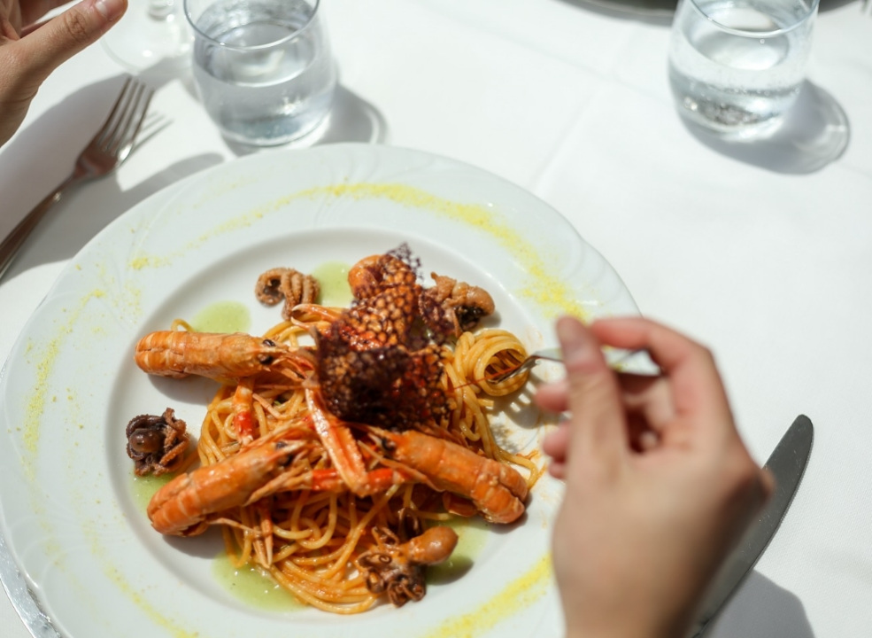 Piatto di spaghetti ai frutti di mare con gamberi e polpo, servito elegantemente.